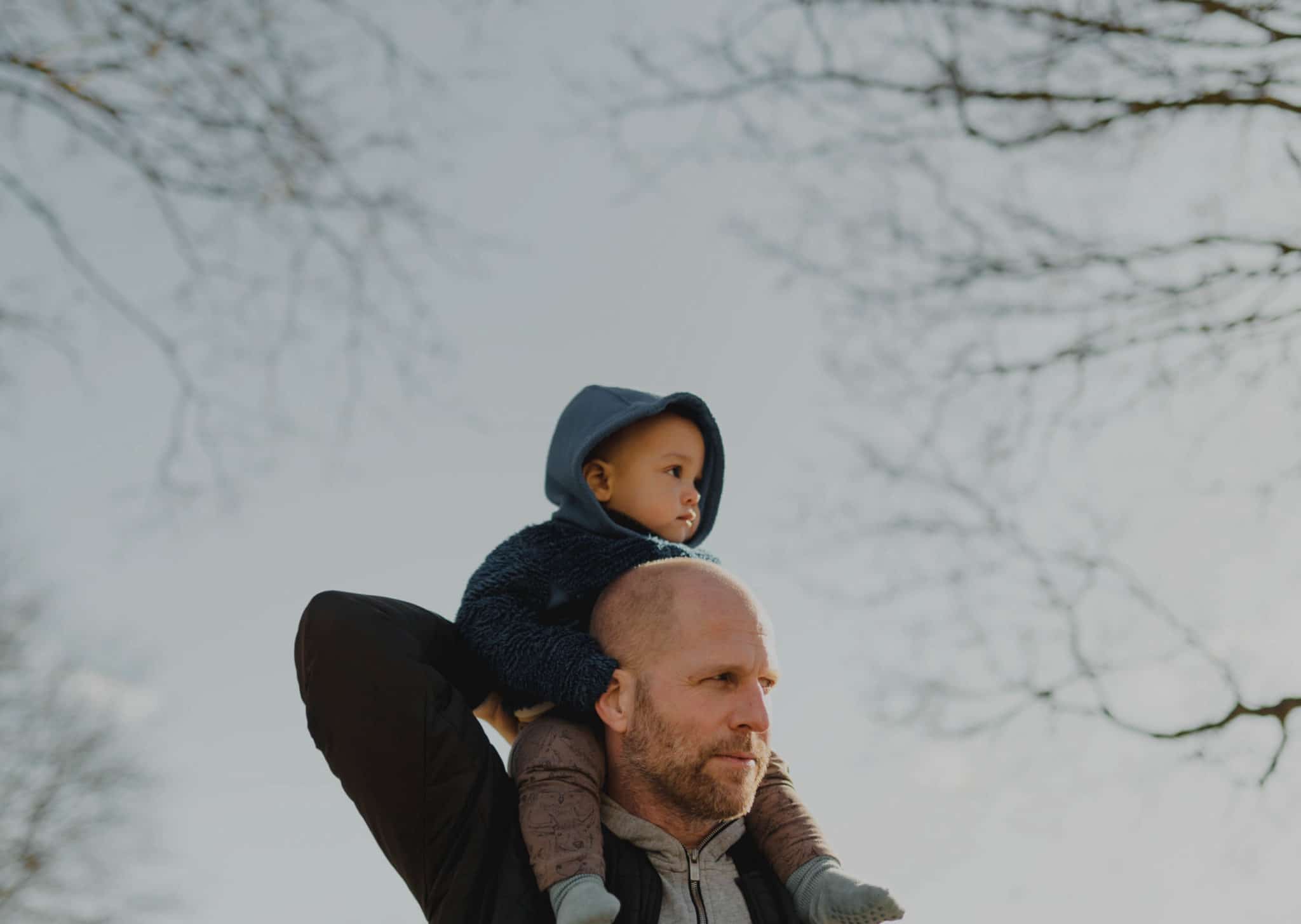 Far bærer sønn på skulder