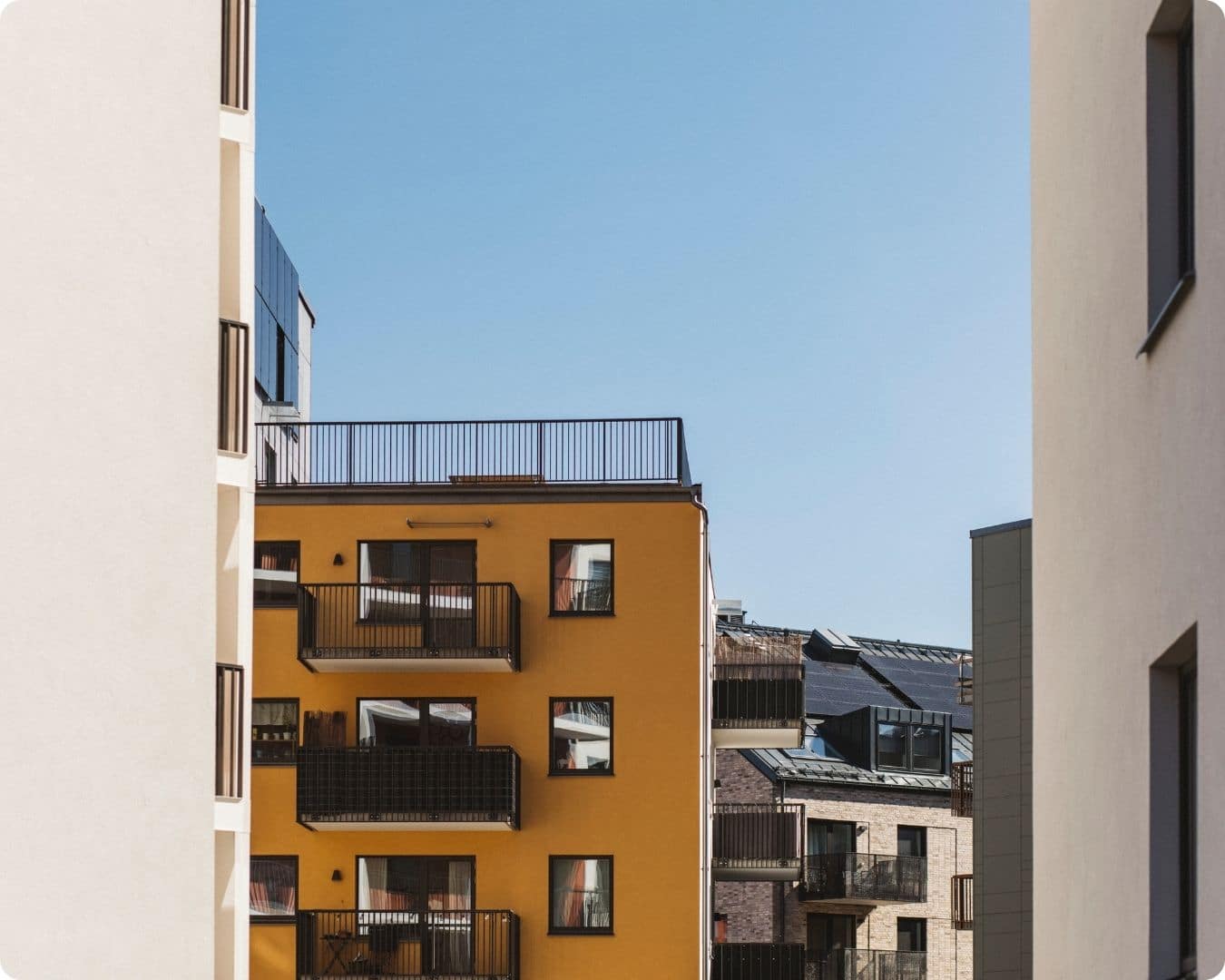 Bilde av leilighetsbygg og blå himmel